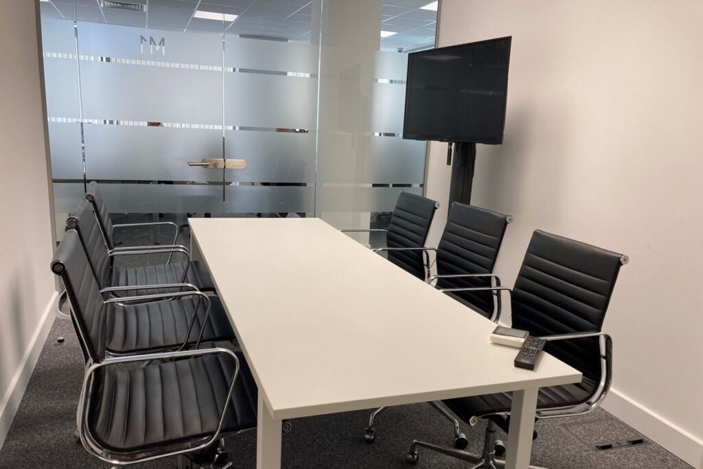 Meeting space with table, chairs and screen